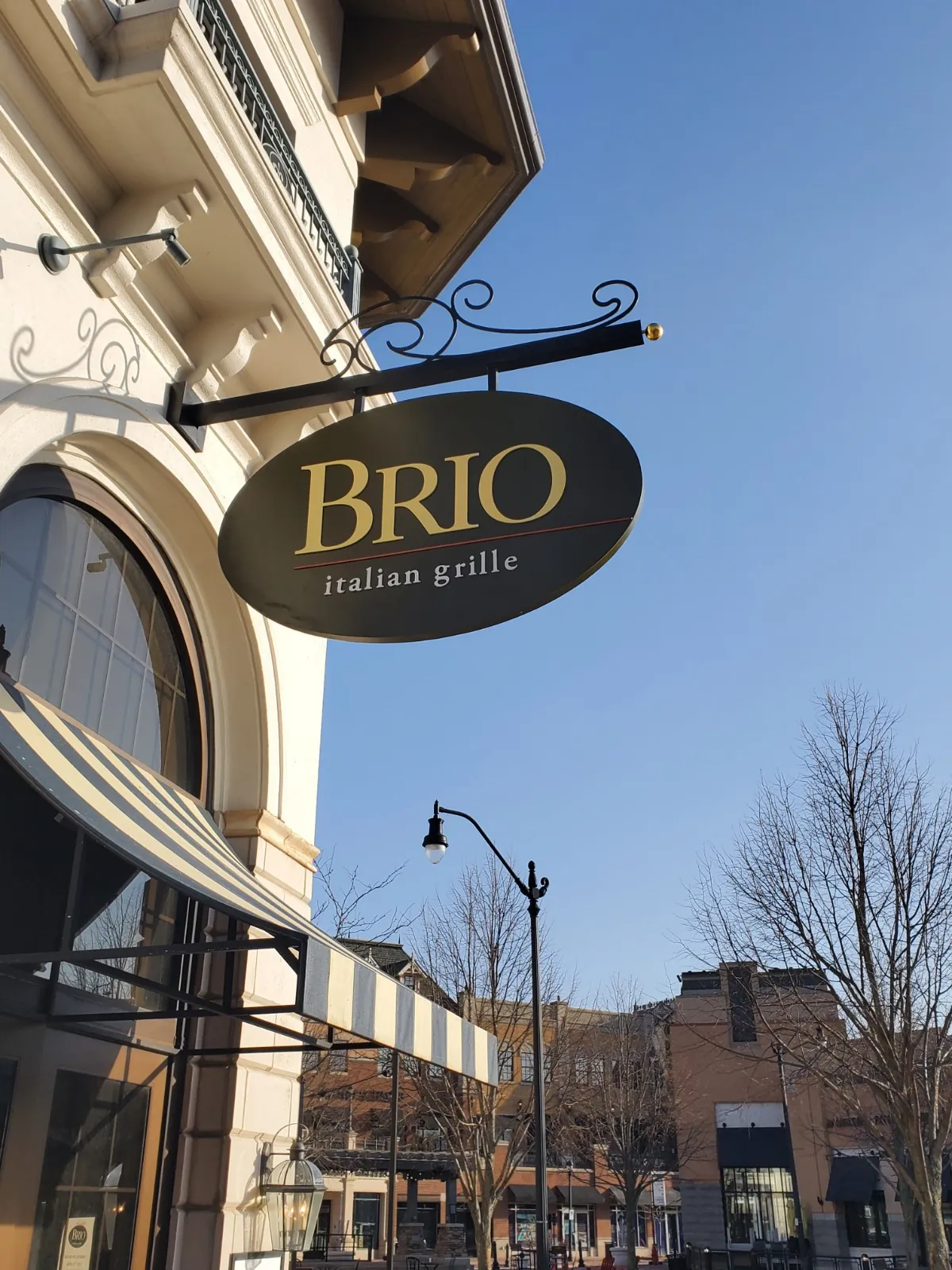 A Brio Italian Grille blade sign on a storefront corner