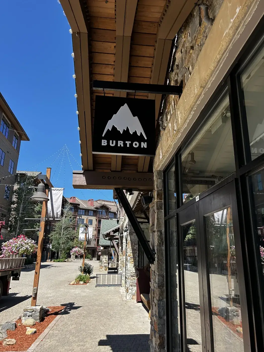 A Burton blade sign projecting from a timber and stone storefront