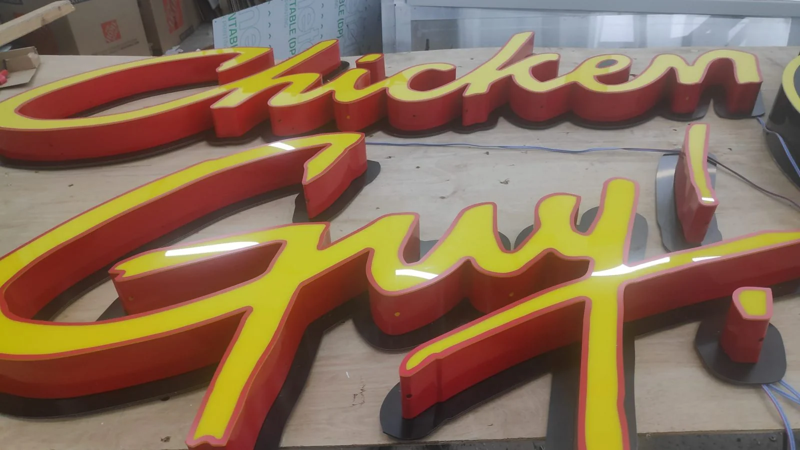 Glossy red Chicken Guy channel letters on a storefront