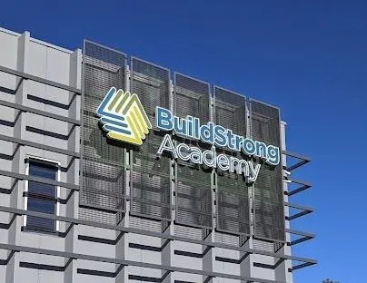 A building with a sign that says buildstrong academy on it.