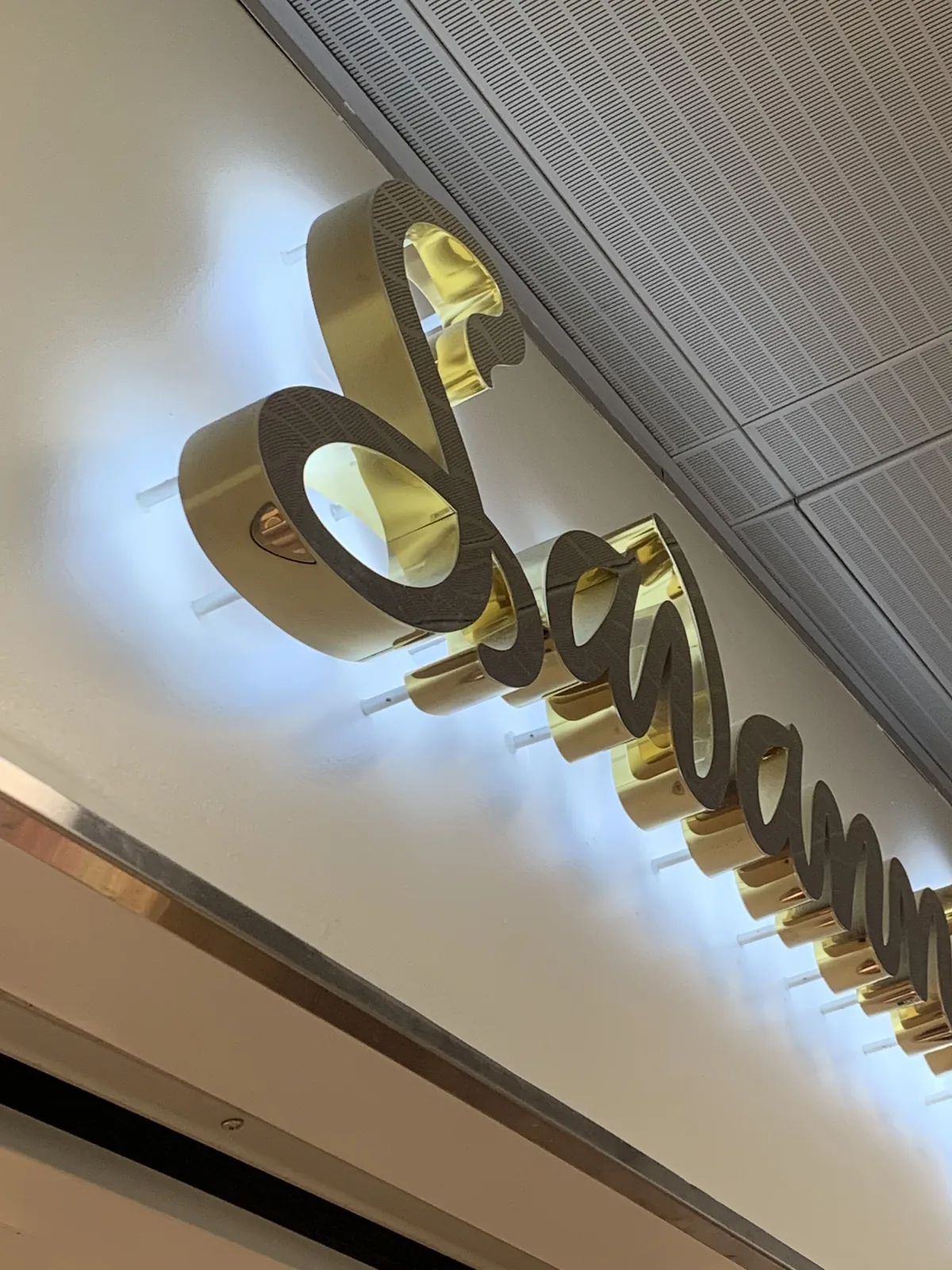 Brass reverse illuminated letters casting a halo glow on the wall behind them
