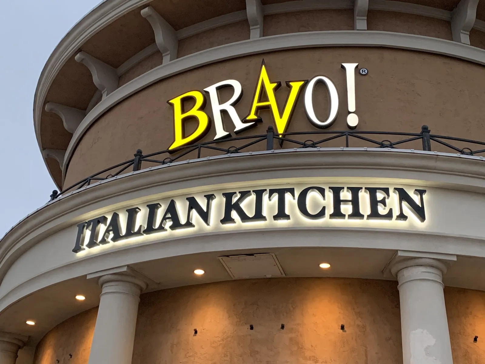 Bravo Italian Kitchen illuminated channel letters glowing at dusk
