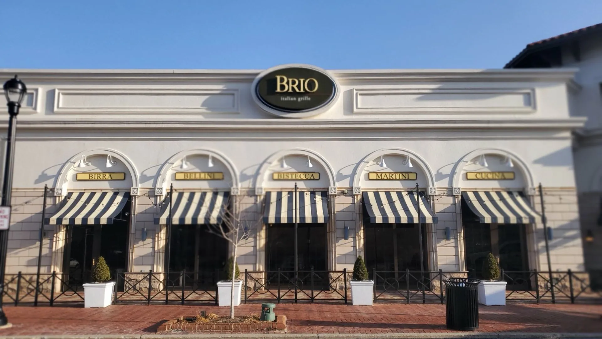 Brio Italian Grille storefront with illuminated signage above the awnings
