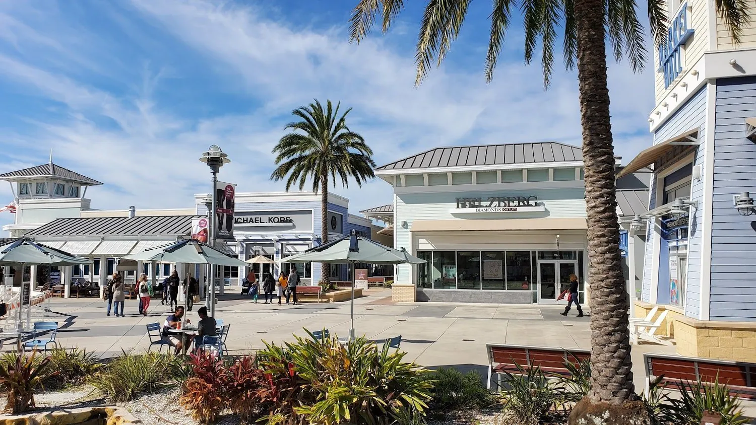 An open air retail center with storefront signage in daylight