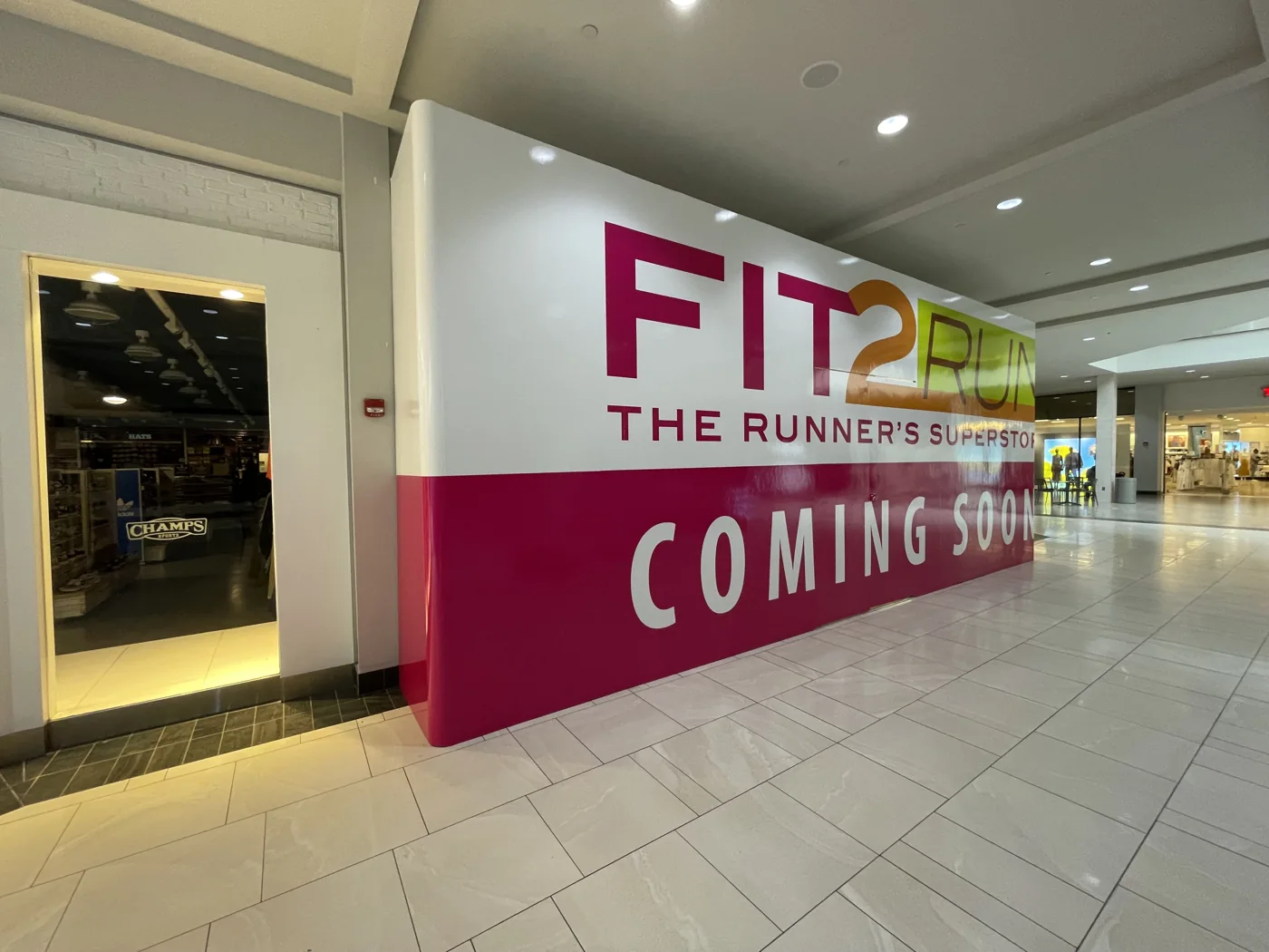 A Fit2Run coming soon barricade wrapping a store under construction
