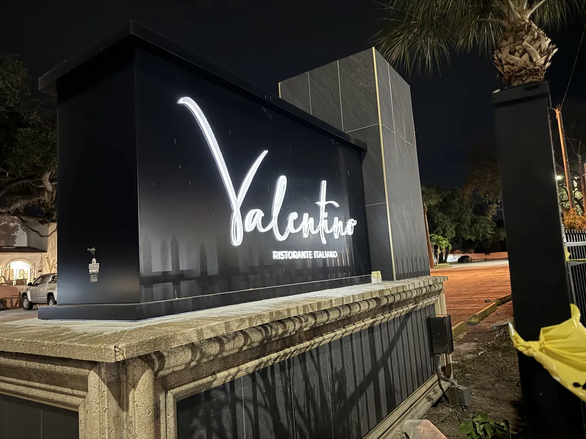 A Valentino Ristorante Italiano monument sign illuminated at night