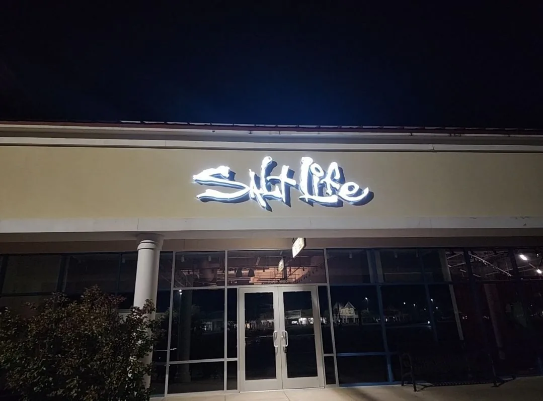 Illuminated Salt Life channel letters lit at night on a storefront