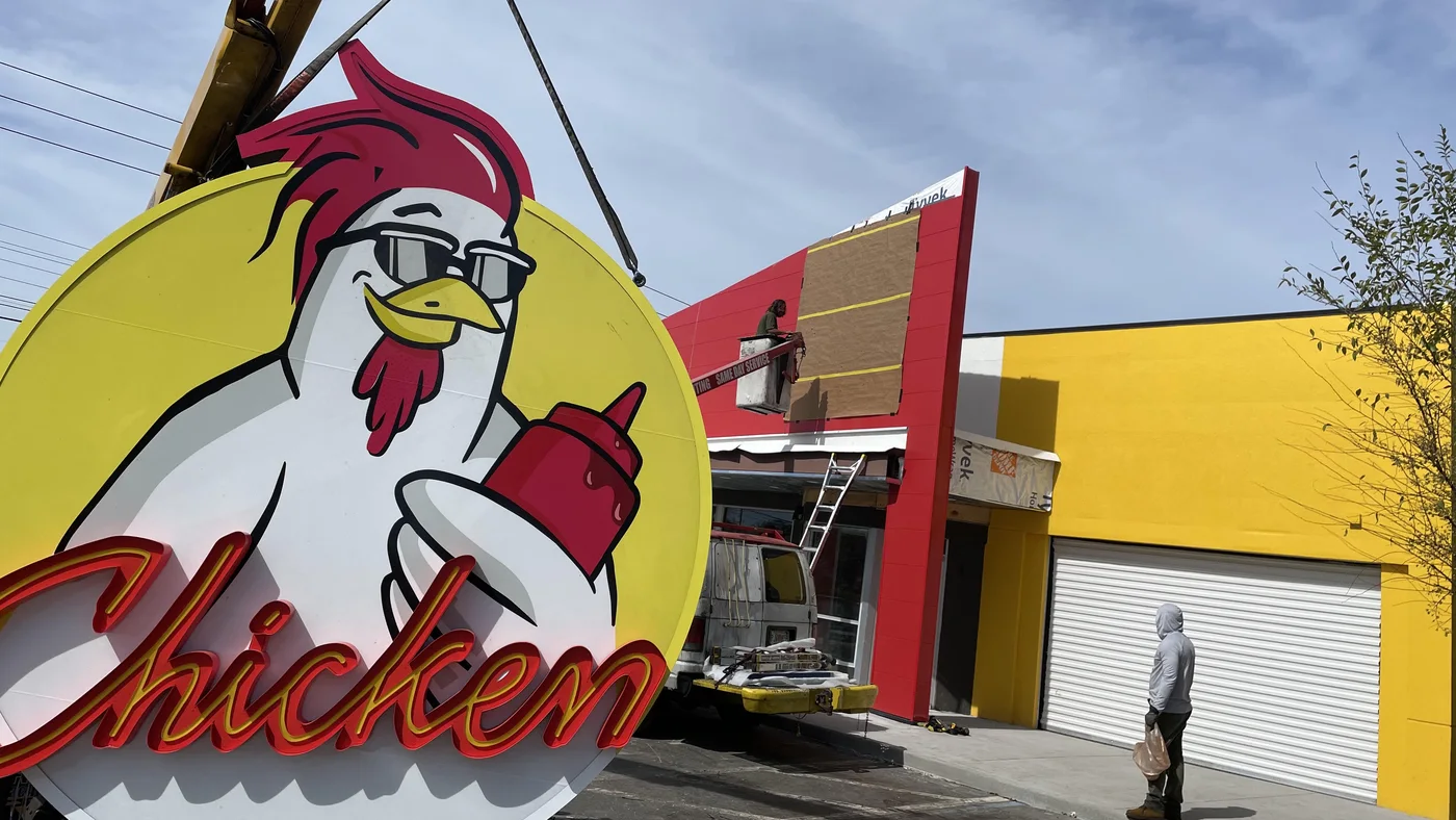 A Chicken Guy! neon channel letter sign being craned into place in Orlando