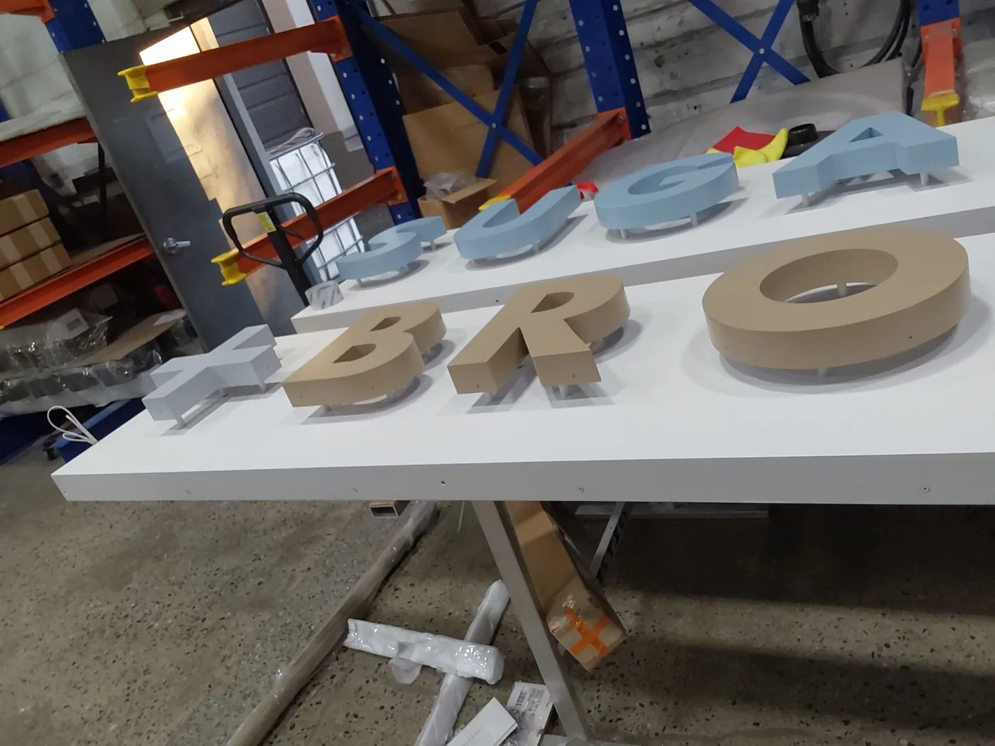 Sugared and Bronzed dimensional letters laid out on the fabrication table